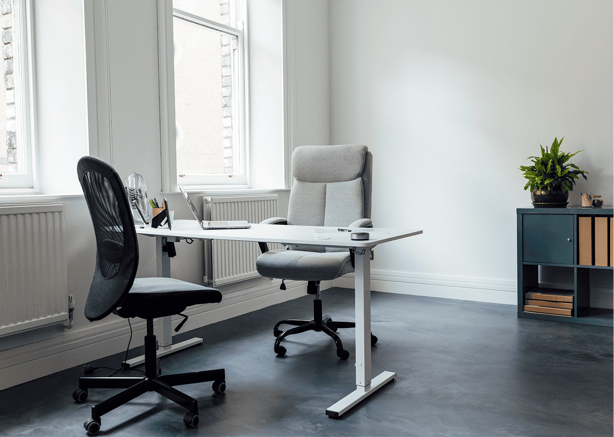 Minimalist office with two chairs and desk.