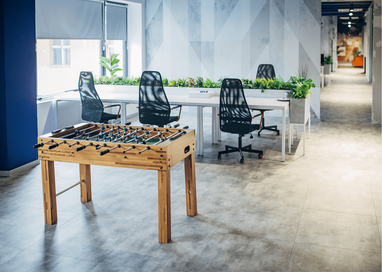 Modern office with foosball table and desks.