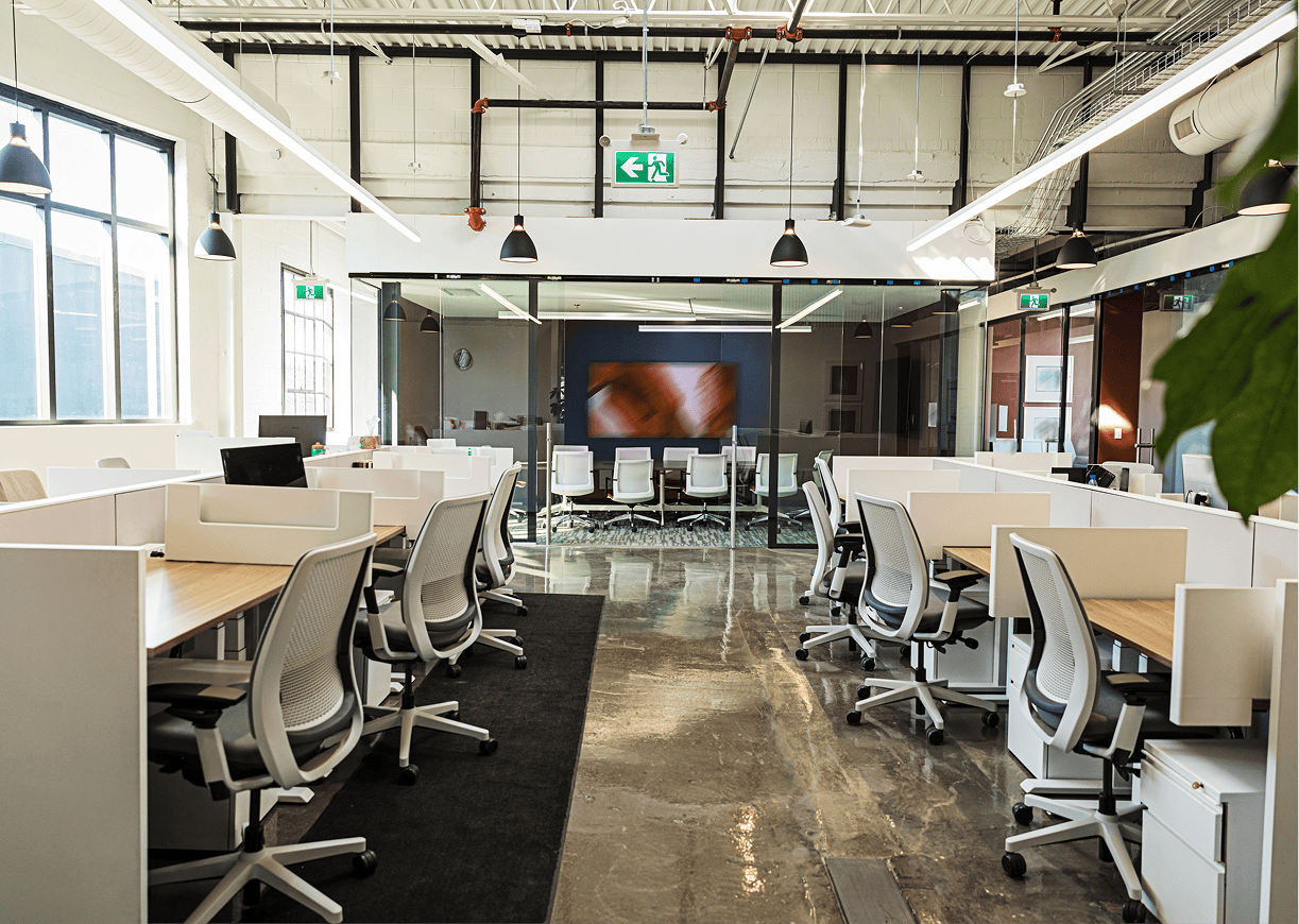 Modern open-plan office with desks and chairs.